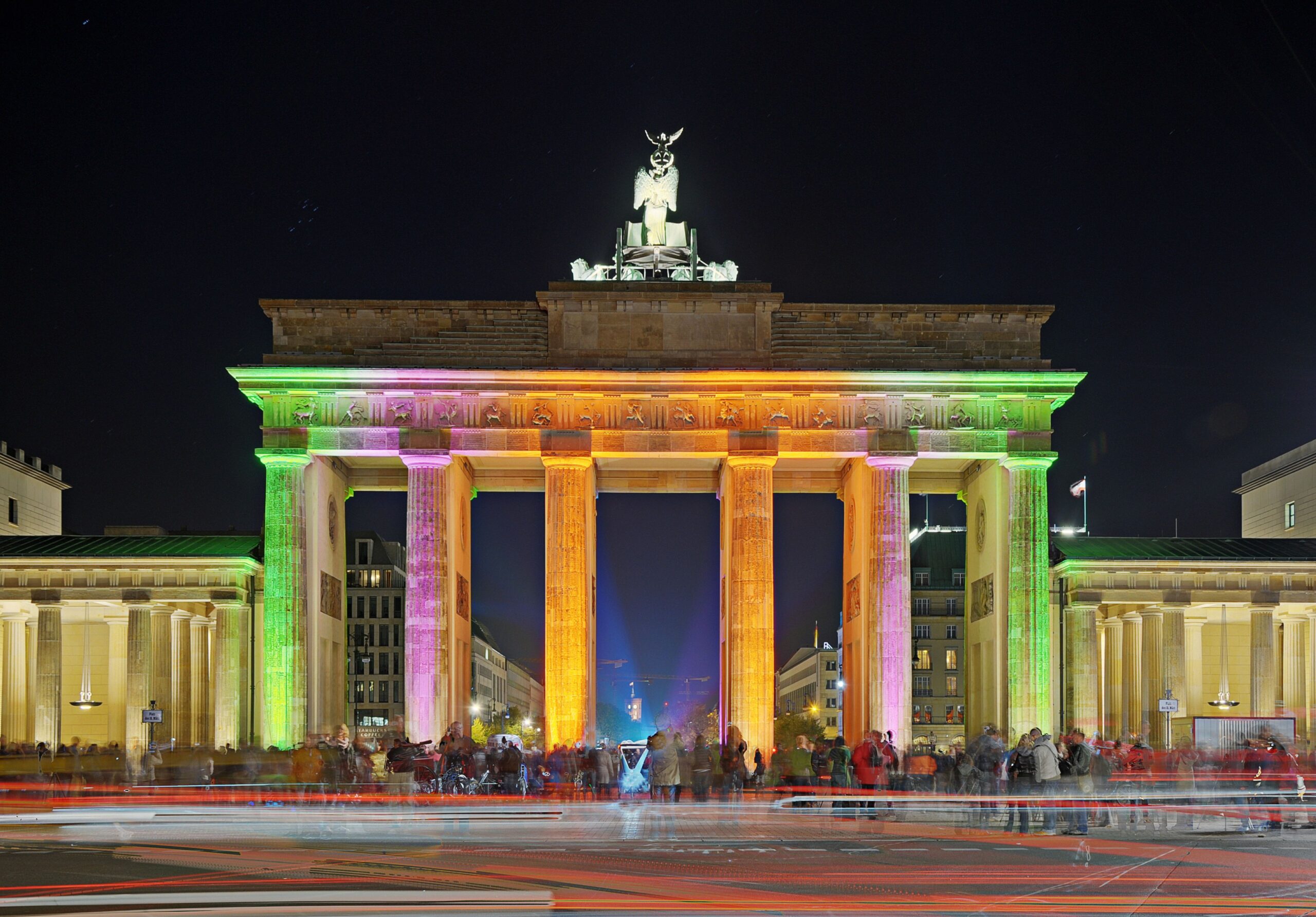 Klassenfahrt Berlin: Brandenburger Tor in Berlin bei Nacht in farbiger Beleuchtung