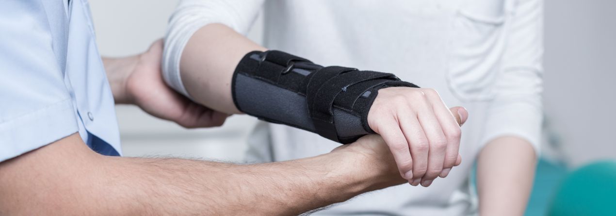 Orthopäde Köln untersucht verletztes Handgelenk und legt Orthese an