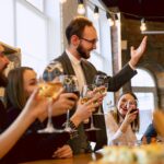 Kollegen stoßen beim festlichen Geschäftsessen an | Zauberer Firmenfeier
